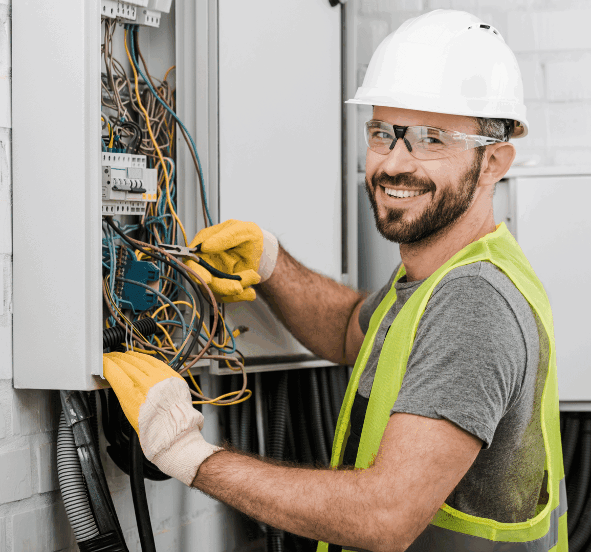 Electrician smiling while working on electrical panel.
